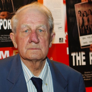 Der Fotograf und KZ-Häftling von Auschwitz: Wilhelm Brasse 2006 vor einem Filmplakat zur Dokumentation über seine Arbeit.