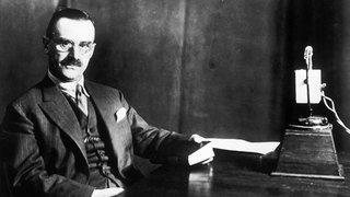 Schwarzweiß-Bild: Thomas Mann vor einem Radiomikrofon.