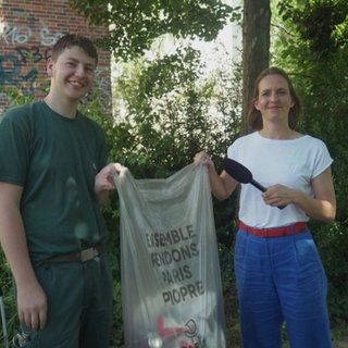 Stefanie und ein Gärtner mit einer Mülltüte in der Hand