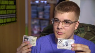 Johnny mit zwei Personalausweisen in der Hand