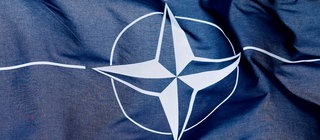 Die NATO-Flagge weht im Wind. Was sind die Aufgaben des Militärbündnisses?