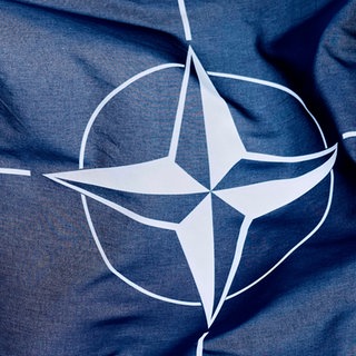 Die NATO-Flagge weht im Wind. Was sind die Aufgaben des Militärbündnisses?