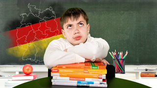 Junge mit fragendem Blick sitzt vor einer Schultafel mit Deutschlandumriss, nach Bundesländern aufgeteilt, darüber die Farben Schwarz-Rot-Gold.