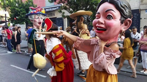 Menschen in Puppen-Verkleidungen bei einer Parade.