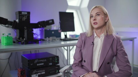 Eine Frau gibt ein Interview in einem Labor.