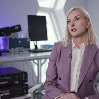 Eine Frau gibt ein Interview in einem Labor.