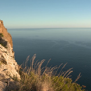 Blick über eine felsige Küstenlandschaft auf das Meer