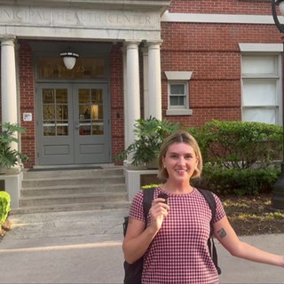 Lily vor einem historischen Gebäude ihrer Universität.