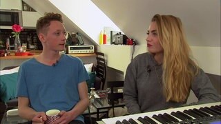 Ein Mann und eine Frau sitzen in einer Küche und unterhalten sich.