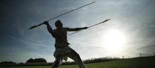 Experimentalarchäologe Rudi Walter schleudert einen Holzspeer mit einer Speerschleuder