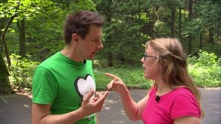 Ein Mann und eine Frau unterhalten sich und zeigen mit dem Finger aufeinander.