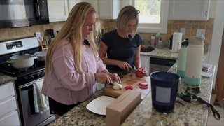 Lily und eine Freundin schneiden in der Küche Gemüse und Mozzarella