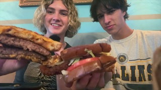 Lily und ihr Freund Michael halten ihr Essen in die Kamera