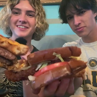 Lily und ihr Freund Michael halten ihr Essen in die Kamera