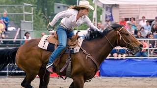 Reiterin mit Cowboyhut auf einem Pferd