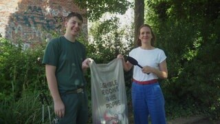 Stefanie und ein Gärtner mit einer Mülltüte in der Hand