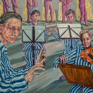 Ein Gemälde zeigt KZ-Häftlinge in blau-weiß gestreifter Kleidung. Eine der Frauen dirigiert, die anderen sitzen teils hinter Notenständern und spielen Geige. Das Gemälde stellt das Mädchenorchester in Auschwitz dar.