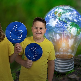 Hintergrund: Eine leuchtende Glühbirne, in der sich die Welt spiegelt. Vordergrund: Zwei Jungen mit einem Daumen-hoch-Schild