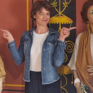 Moderatorin Lena Ganschow zwischen zwei in römische Togen gekleidete Schaufensterpuppen