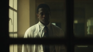 Spielszene: Frantz Fanon in weißem Arztkittel: Auch als Psychiater kämpft er gegen die Folgen von Kolonialisierung und Krieg.