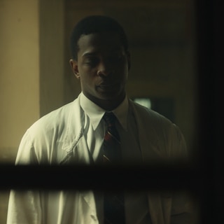 Spielszene: Frantz Fanon in weißem Arztkittel: Auch als Psychiater kämpft er gegen die Folgen von Kolonialisierung und Krieg.