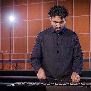 Ein Orchestermusiker spielt auf einem großen Glockenspiel. Dieses Instrument gehört zur Gruppe der Schlaginstrumente.