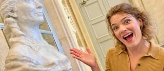 Host Lena Ganschow vor der Statue der Frauenrechtlerin Olympe de Gouges.