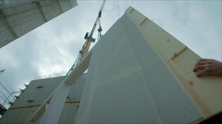 Bauarbeiter auf der Baustelle eines Holzhochhauses.