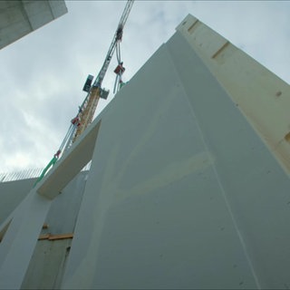 Bauarbeiter auf der Baustelle eines Holzhochhauses.