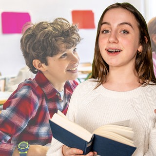 Ein Mädchen hält ein Buch in der Hand und schaut in die Kamera, im Hintergrund sind Kinder in einem Klassenraum zu sehen, die zuhören und klatschen.